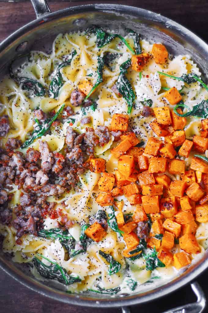 ingredients for Creamy Butternut Squash Pasta with Sausage and Spinach and Parmesan Cream Sauce in a stainless steel pan