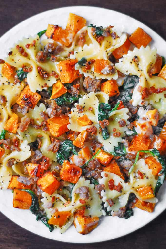 Creamy Butternut Squash Pasta with Sausage and Spinach on a white plate