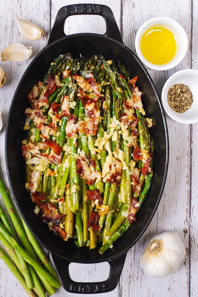 Cheesy Baked Asparagus with Garlic, Bacon, Olive Oil in a cast-iron pan