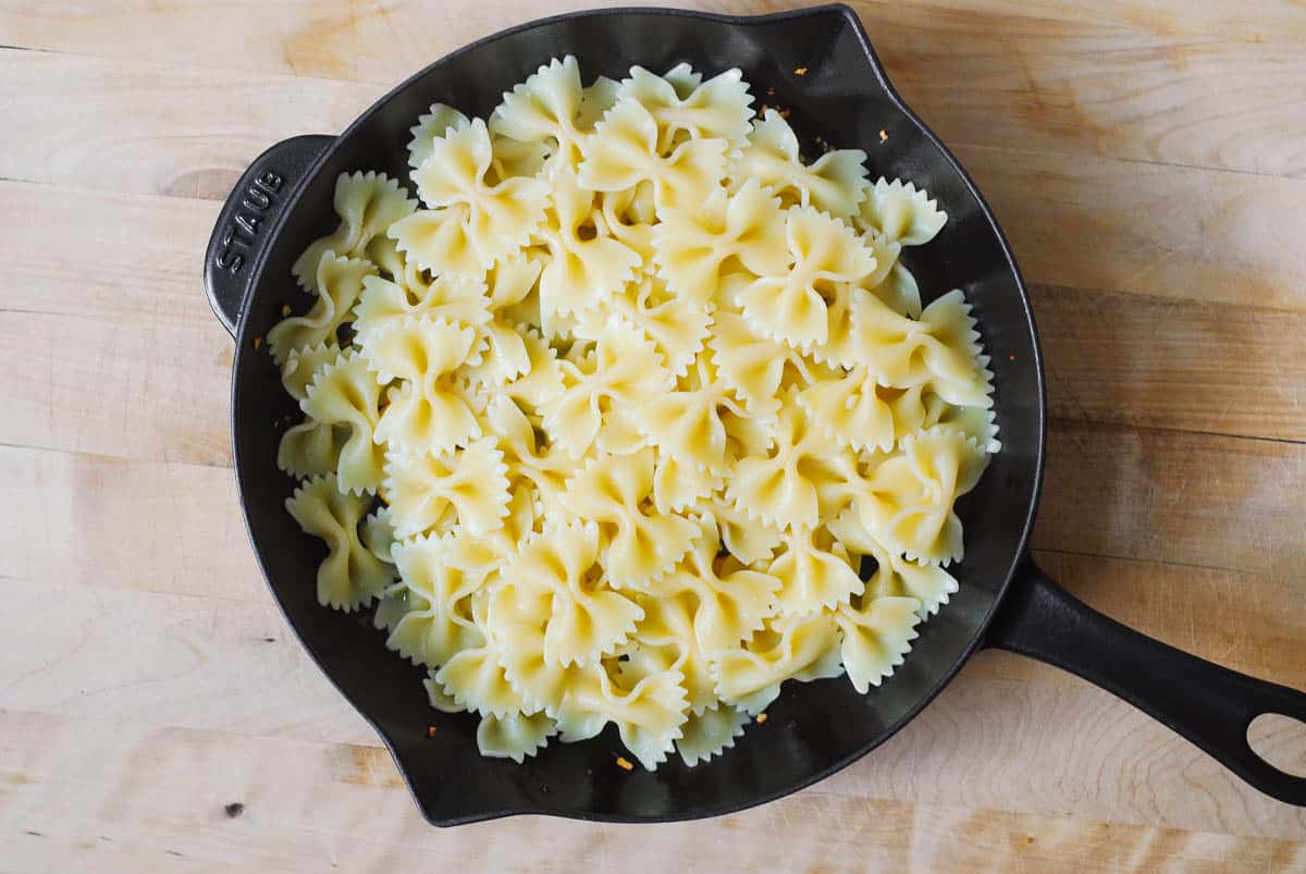 cooked bow tie pasta in a cast iron skillet