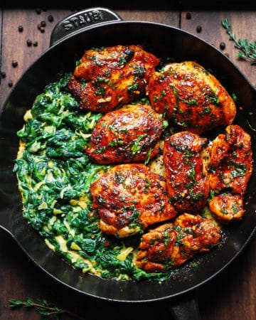 smoked paprika chicken with creamed spinach in a cast-iron skillet