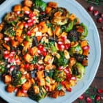 Roasted Brussels Sprouts Salad with Figs, Almonds, Butternut Squash, and Pomegranate Seeds on a gray plate
