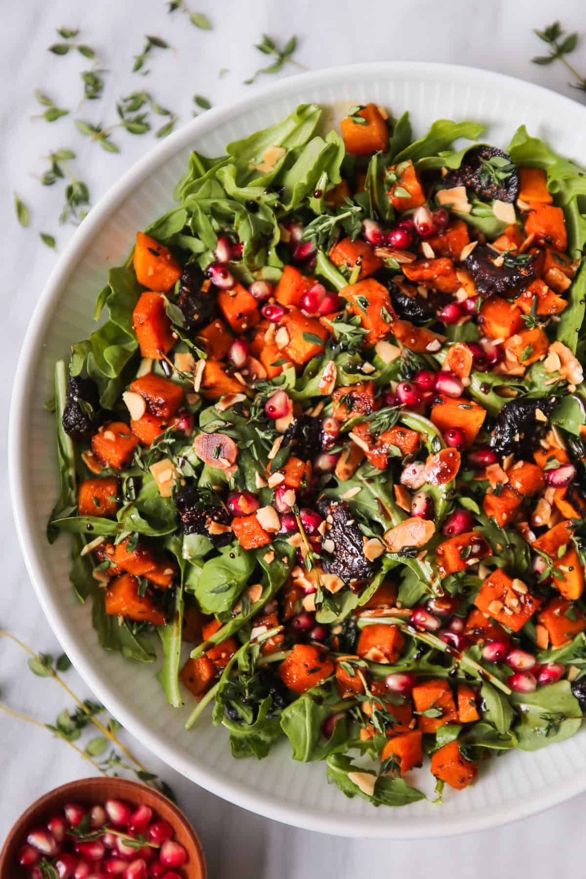Fall Salad with Butternut Squash, Arugula, Dried Figs, and Almonds in a white bowl