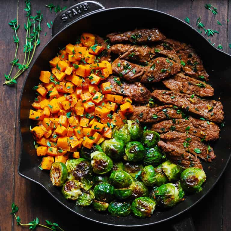 Garlic Butter Steak with Brussels Sprouts and Butternut Squash in a cast-iron skillet