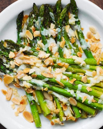 Roasted Asparagus with Almonds and Parmesan on a white plate