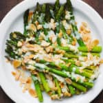 Roasted Asparagus with Almonds and Parmesan on a white plate