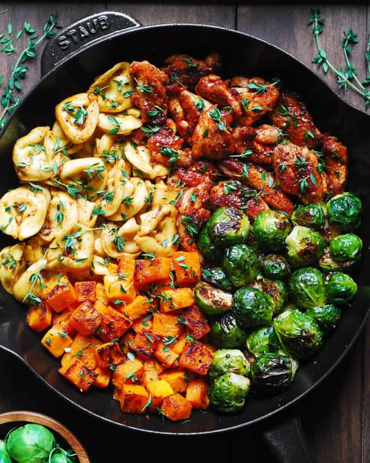 seared chicken, tortellini with roasted butternut squash and brussels sprouts in a cast-iron skillet