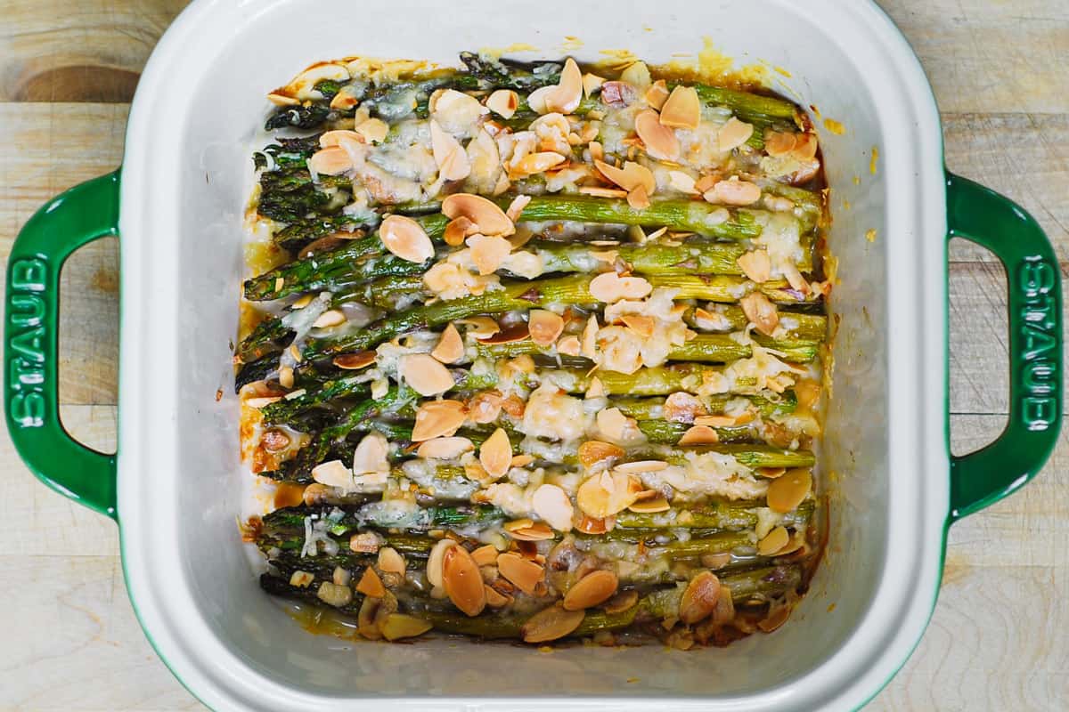 baked asparagus with toasted almonds and parmesan in a baking dish