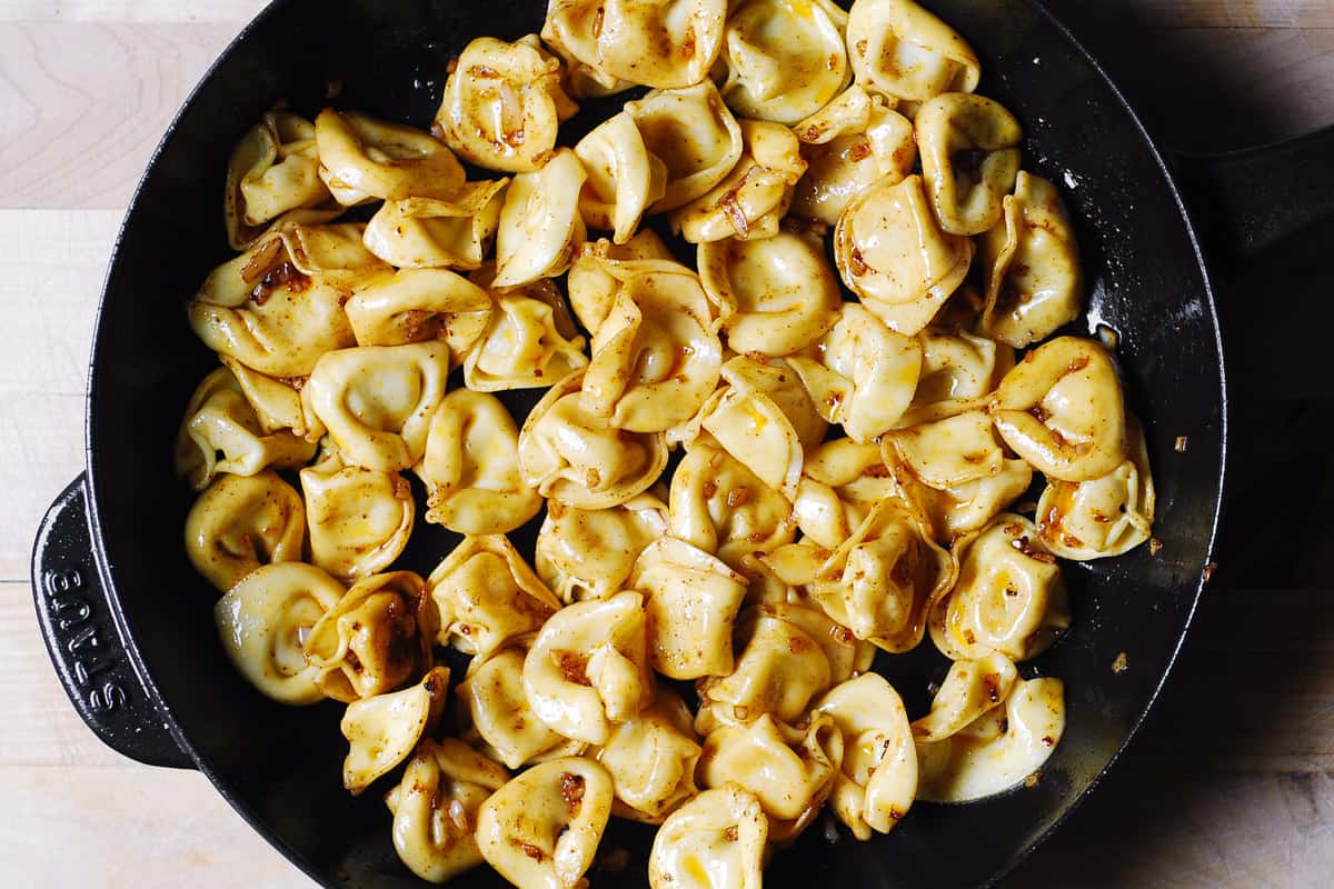 cooked tortellini with butter sauce in a cast-iron skillet