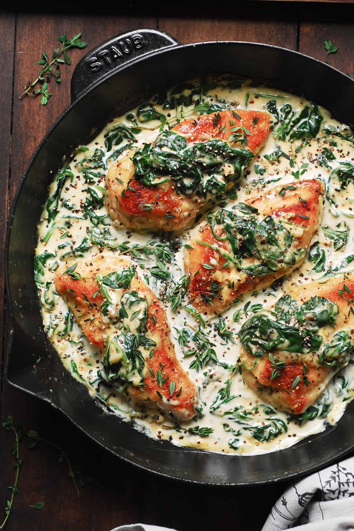 creamy spinach chicken breasts in a cast-iron pan