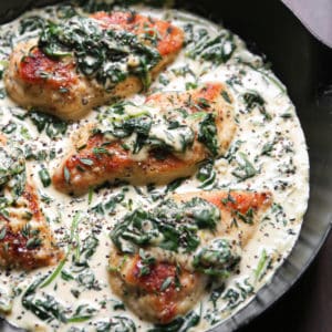 creamy spinach chicken breasts in a cast-iron pan