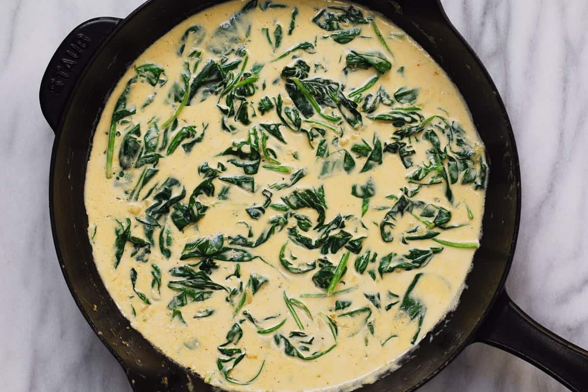 creamy spinach sauce in a cast-iron skillet