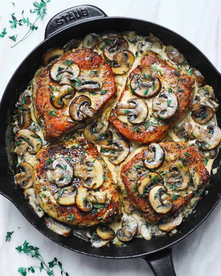 creamy pork chops with mushroom sauce in a cast-iron skillet