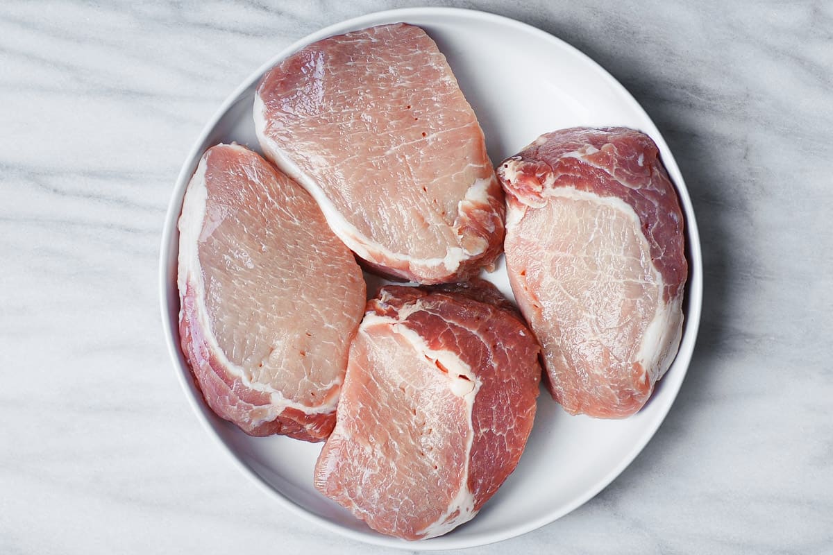 raw pork chops on a plate
