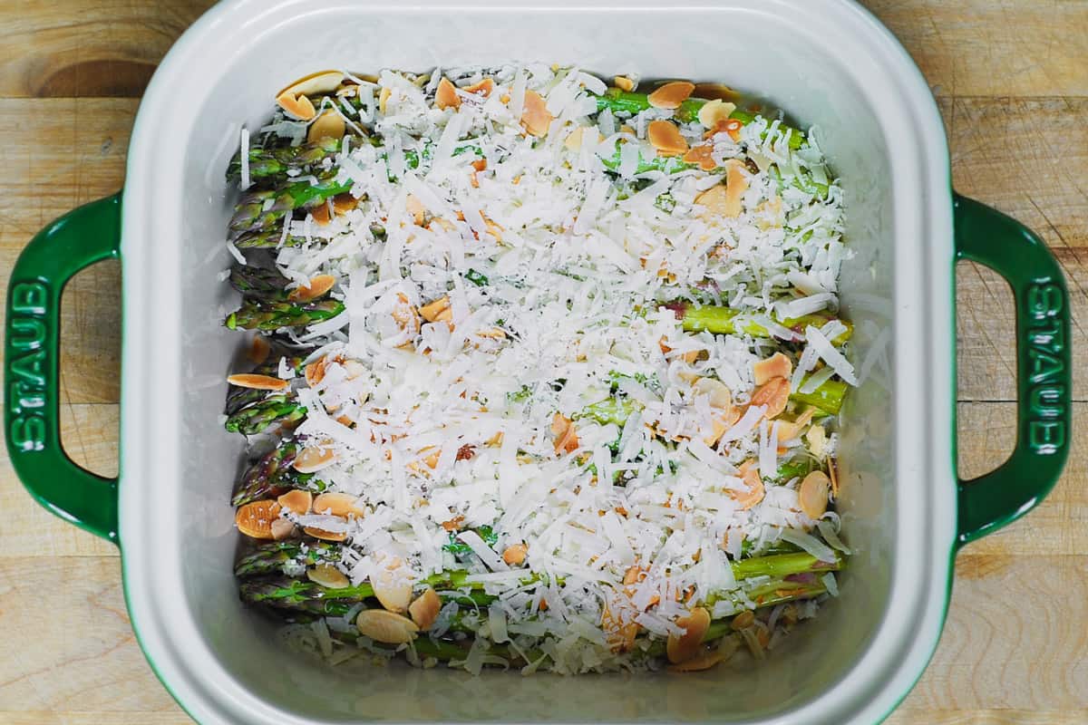 remaining half of shredded parmesan cheese over asparagus in a baking dish