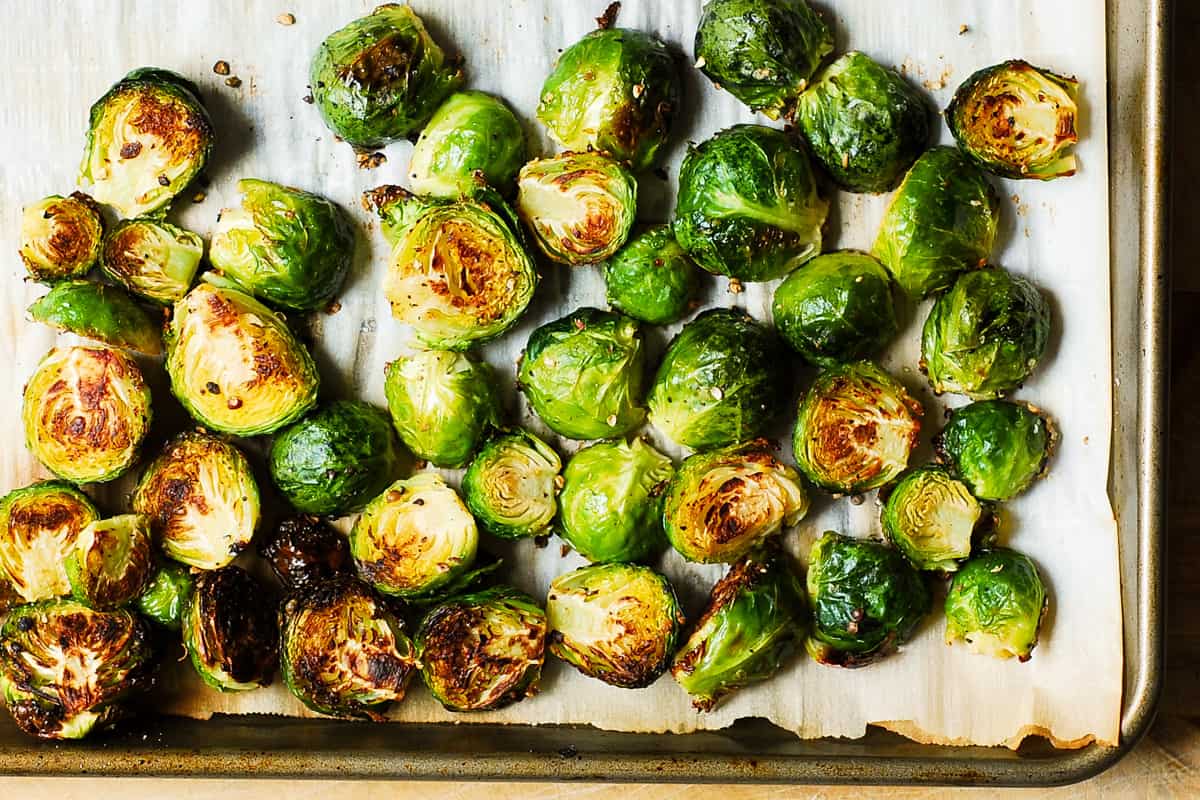 roasted brussels sprouts on a parchment paper lined baking sheet