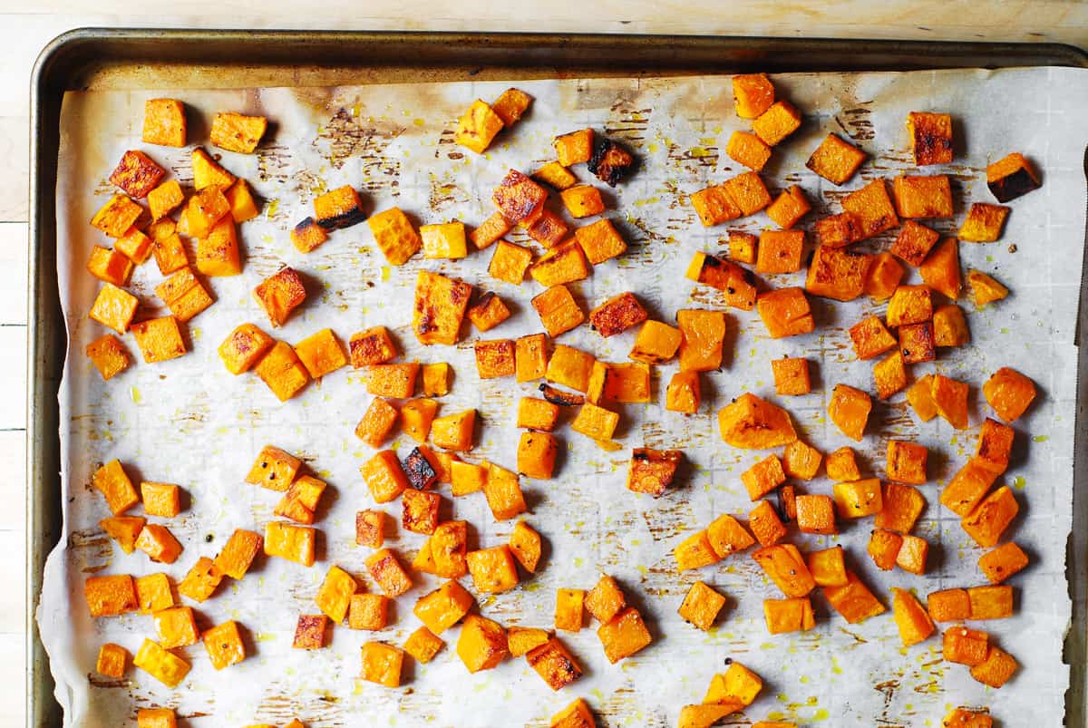 roasted butternut squash on a parchment paper lined baking sheet