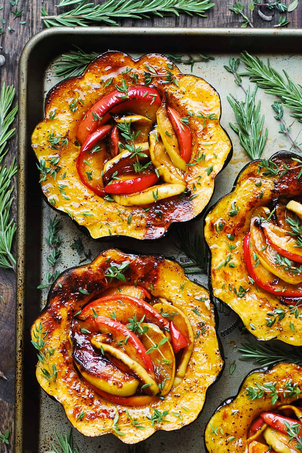 acorn squash halves stuffed with apples on a baking sheet