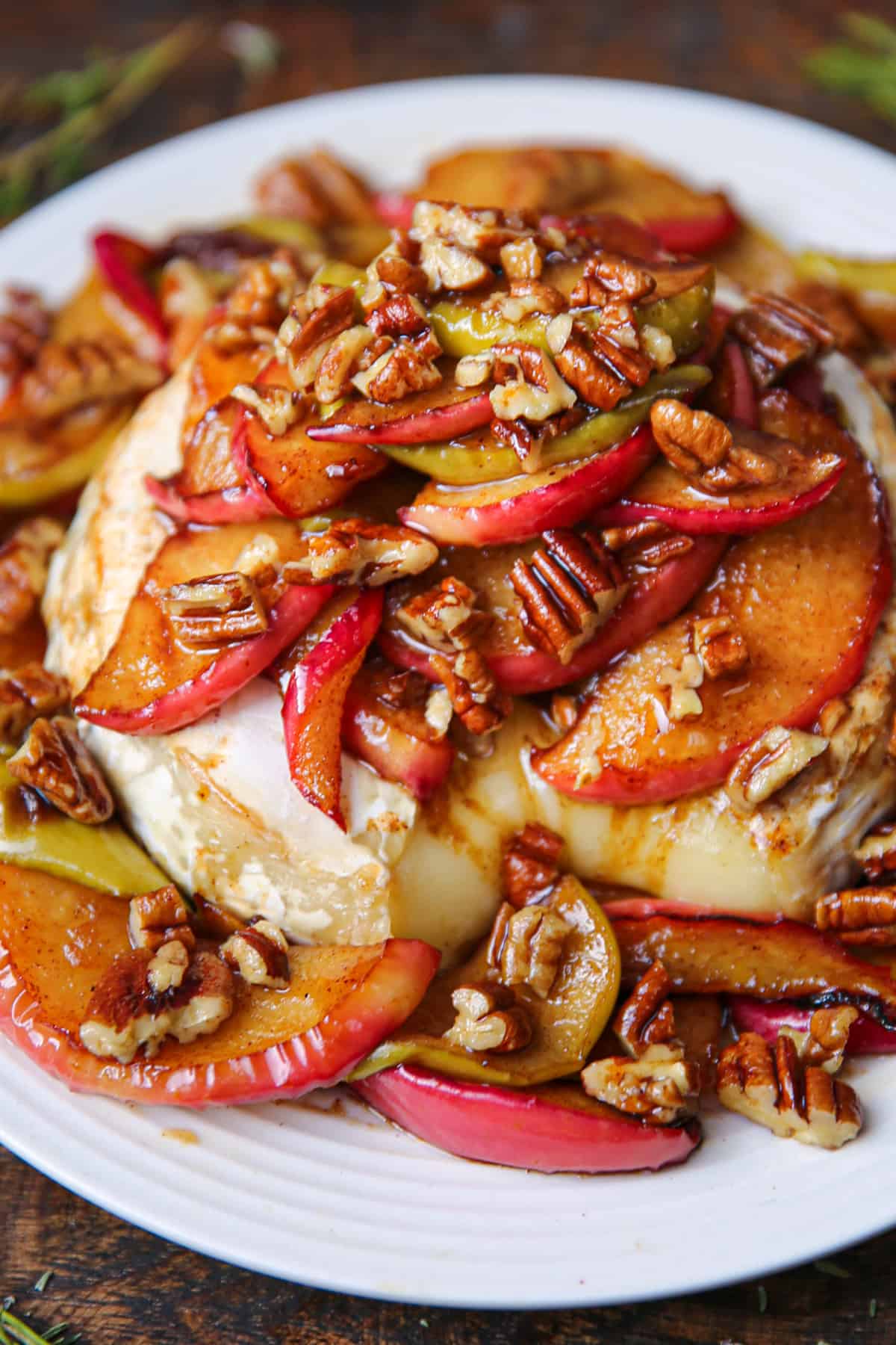 baked brie with apples and pecans on a white plate