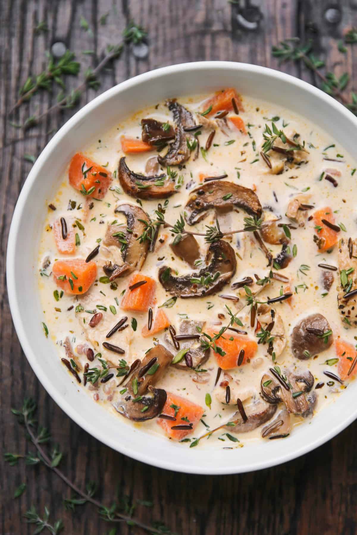 creamy chicken wild rice soup with mushrooms and sweet potatoes in a white bowl