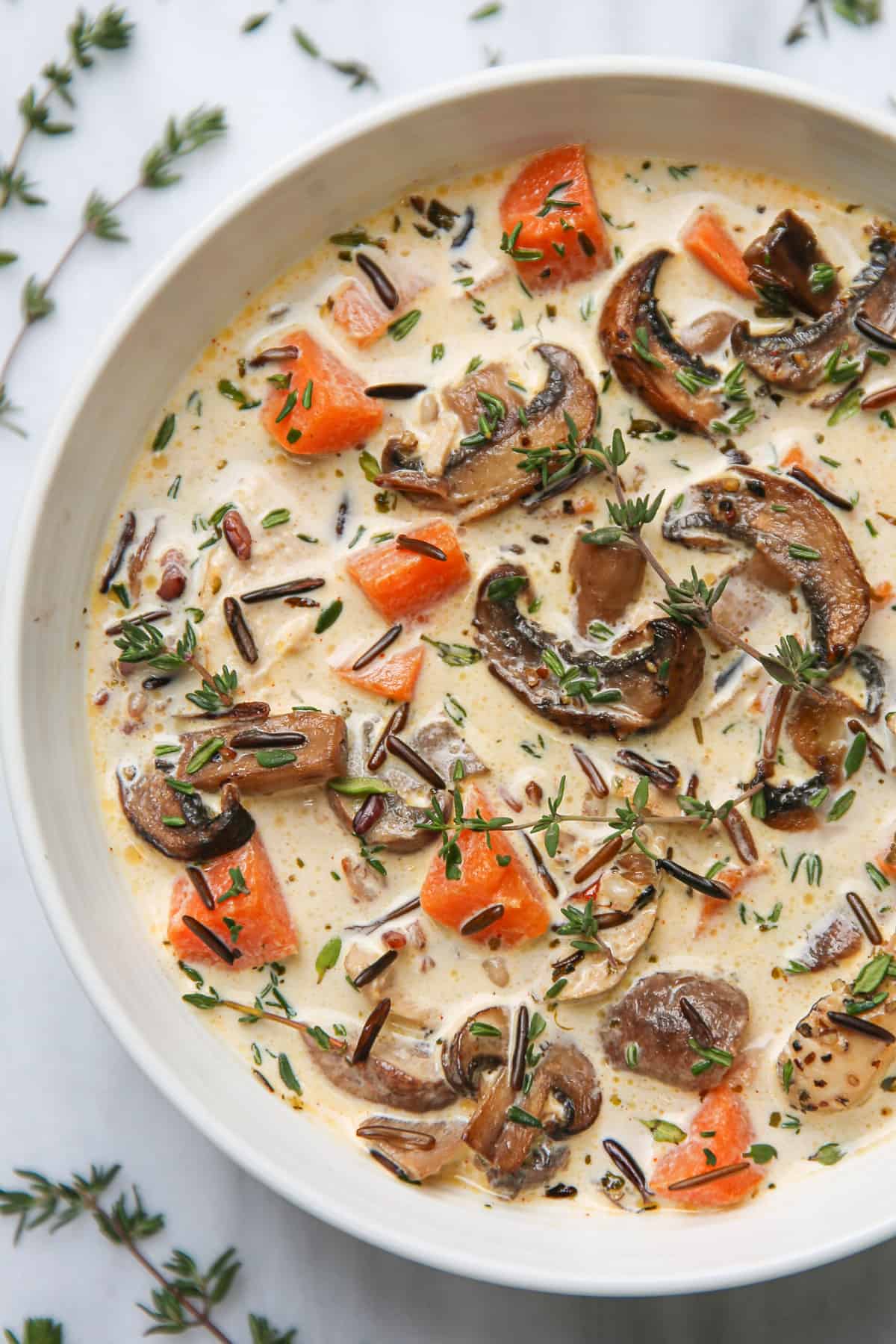 creamy chicken wild rice soup with mushrooms and sweet potatoes in a white bowl