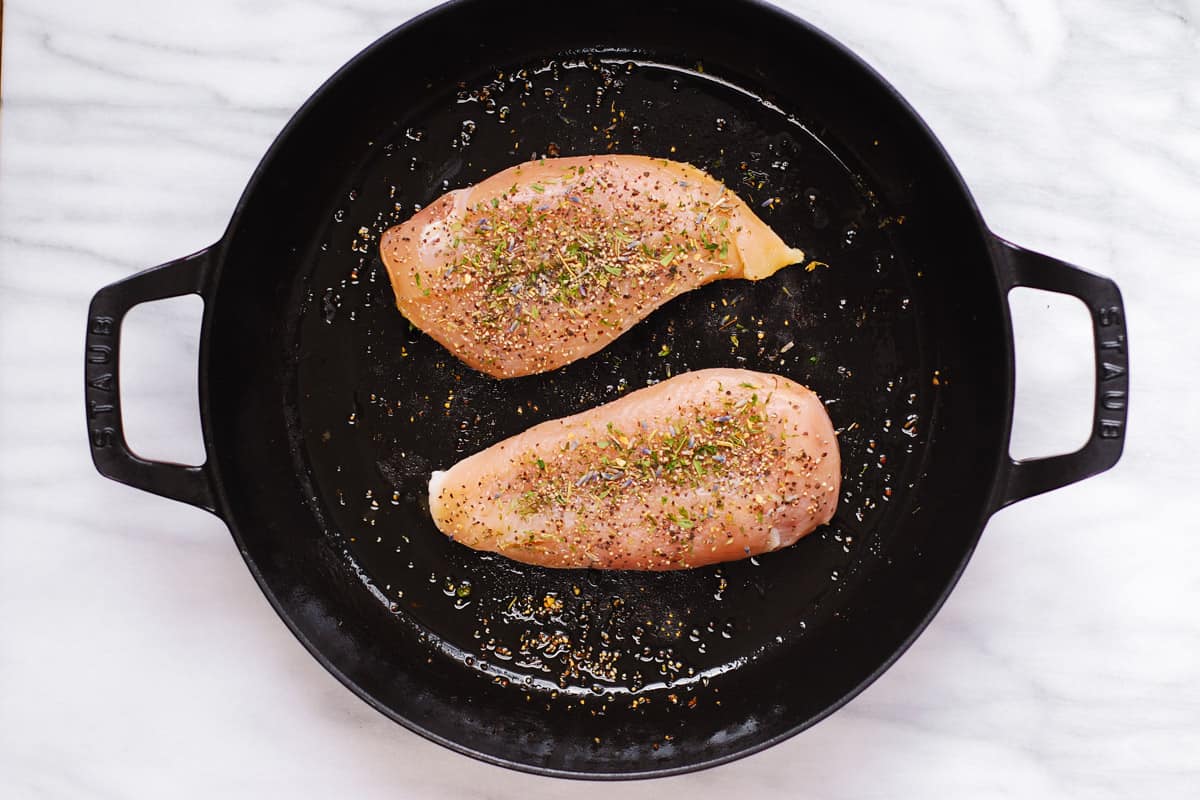 seasoned chicken breasts in a cast iron pan