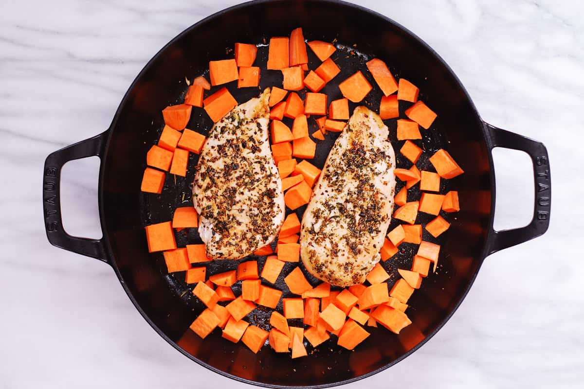 sweet potatoes seared chicken breasts in a cast iron pan