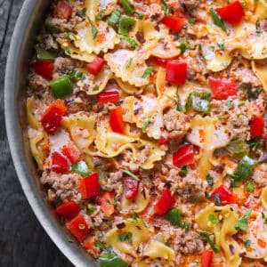 creamy italian sausage pasta with bell peppers and marinara sauce in a stainless steel pan
