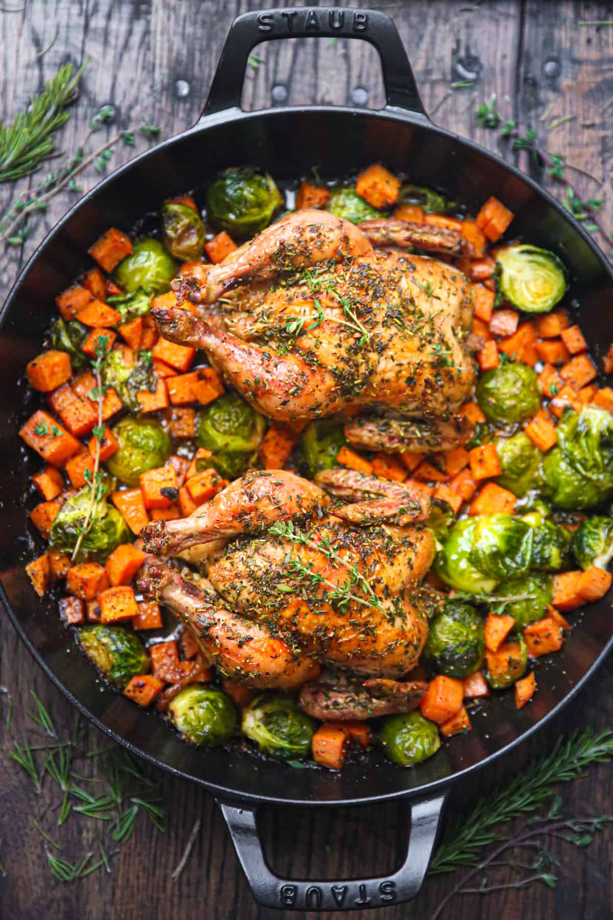 roasted Cornish hens with vegetables in a cast iron pan