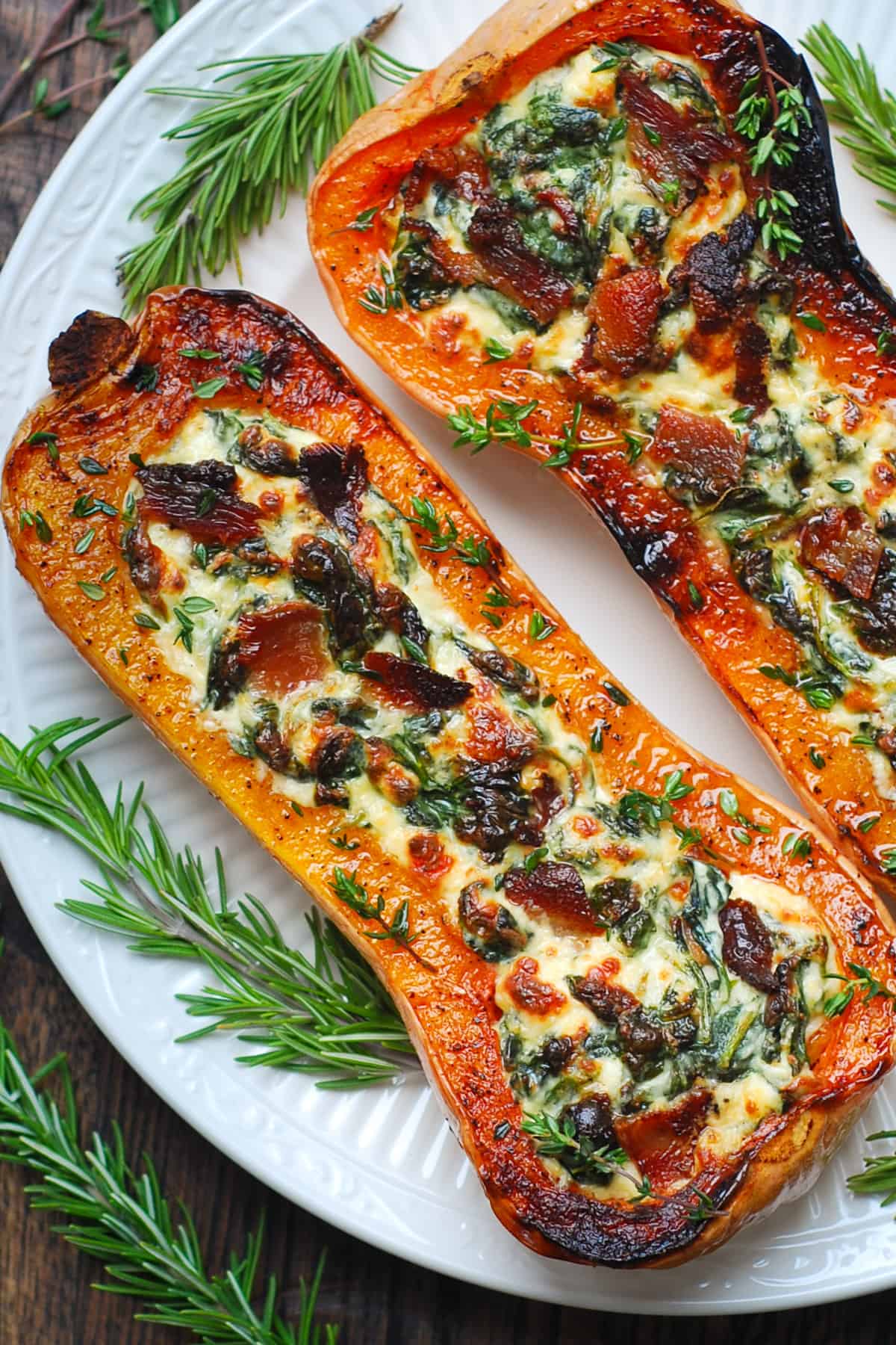 stuffed butternut squash with spinach, bacon, and cheese on a white plate