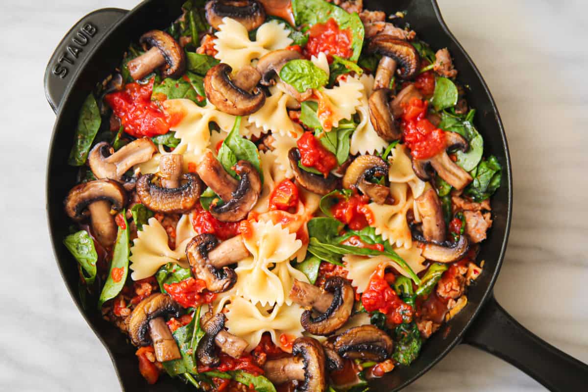 Italian sausage pasta with spinach, mushrooms, and tomato sauce