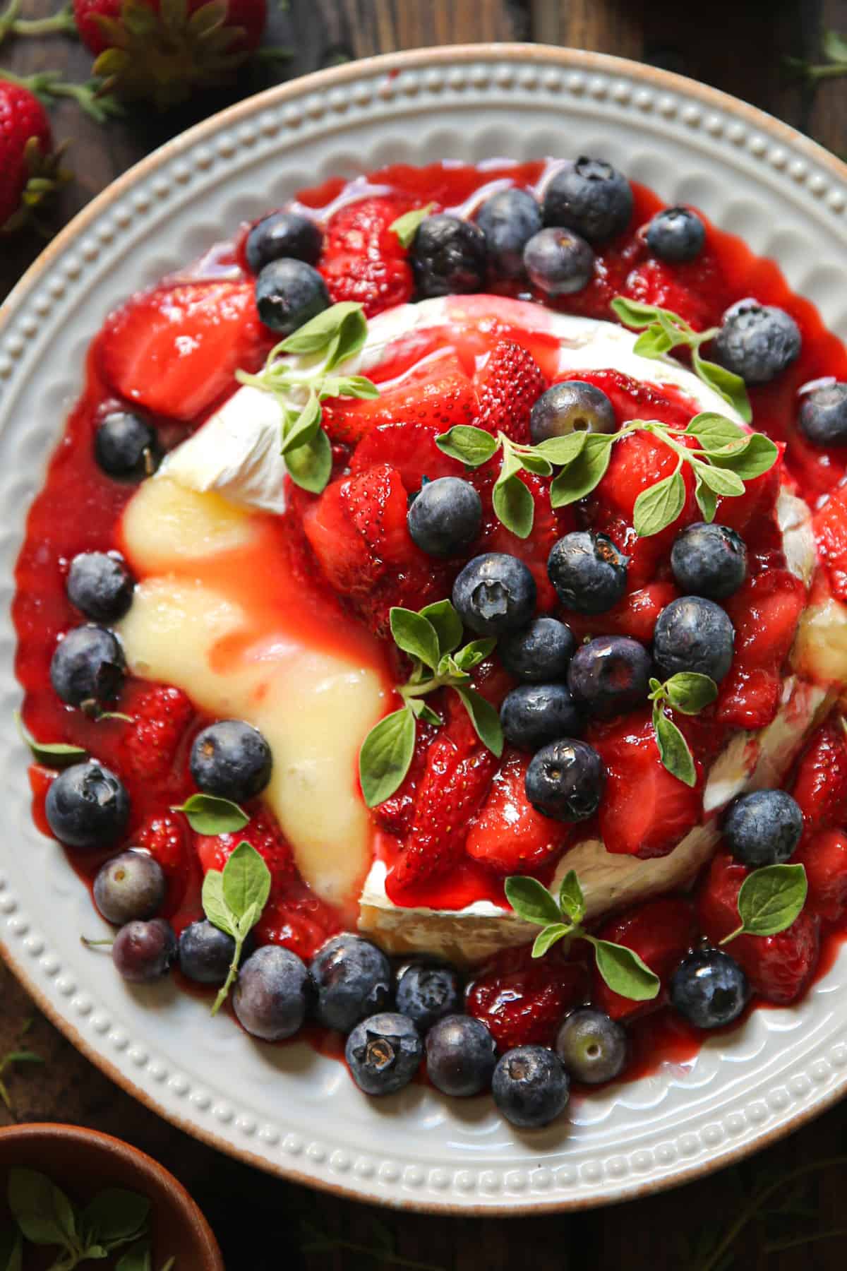 strawberry baked brie with blueberries on a plate