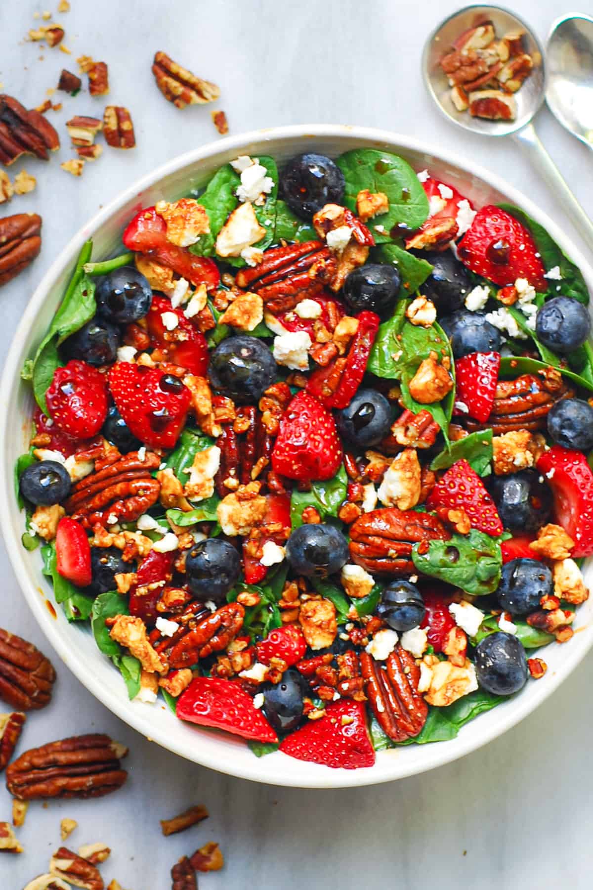 strawberry spinach salad with pecans, blueberries, feta cheese, and balsamic salad dressing
