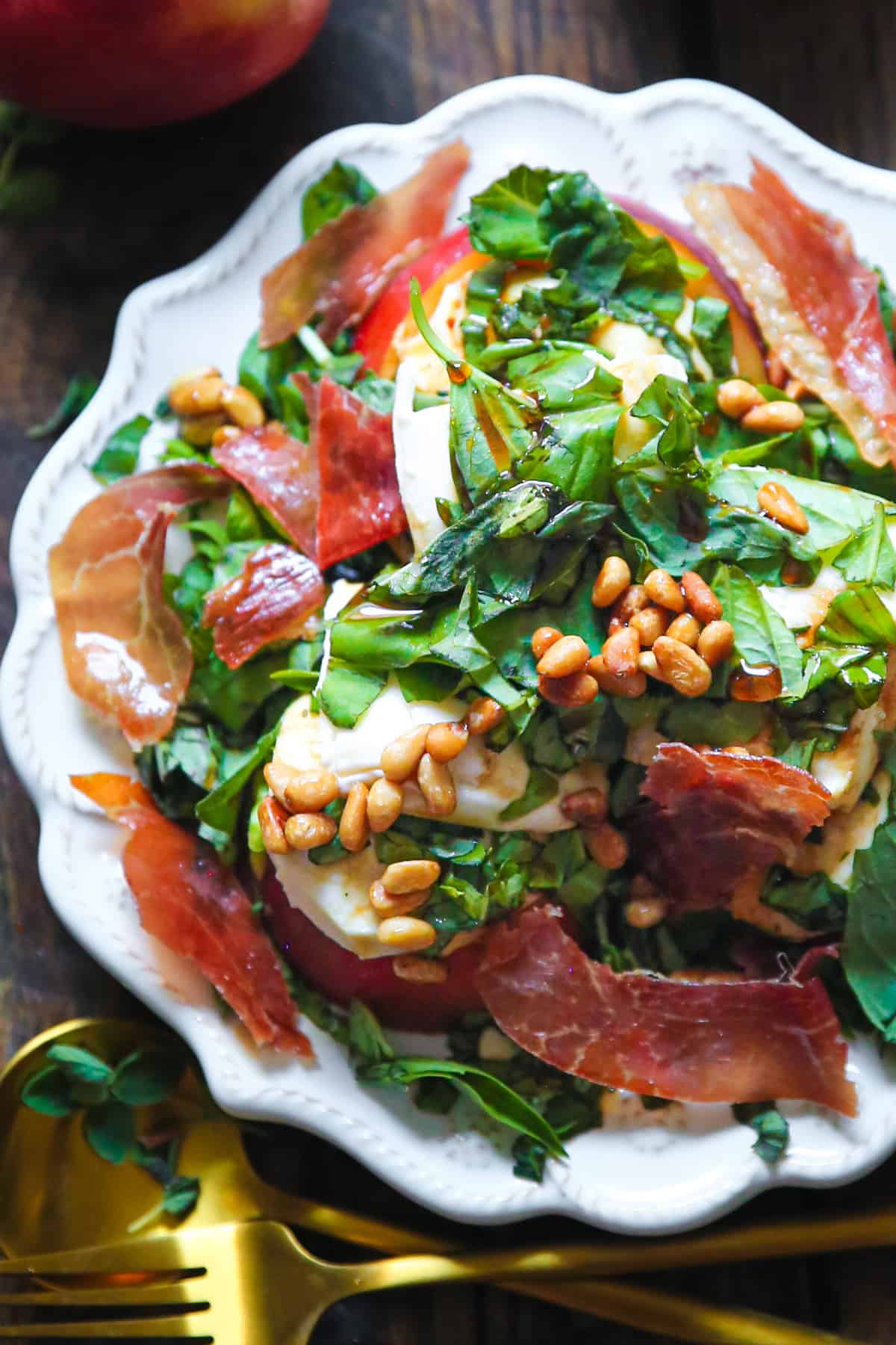 Peach Mozzarella Salad with Basil, Prosciutto, and Pine Nuts on a plate