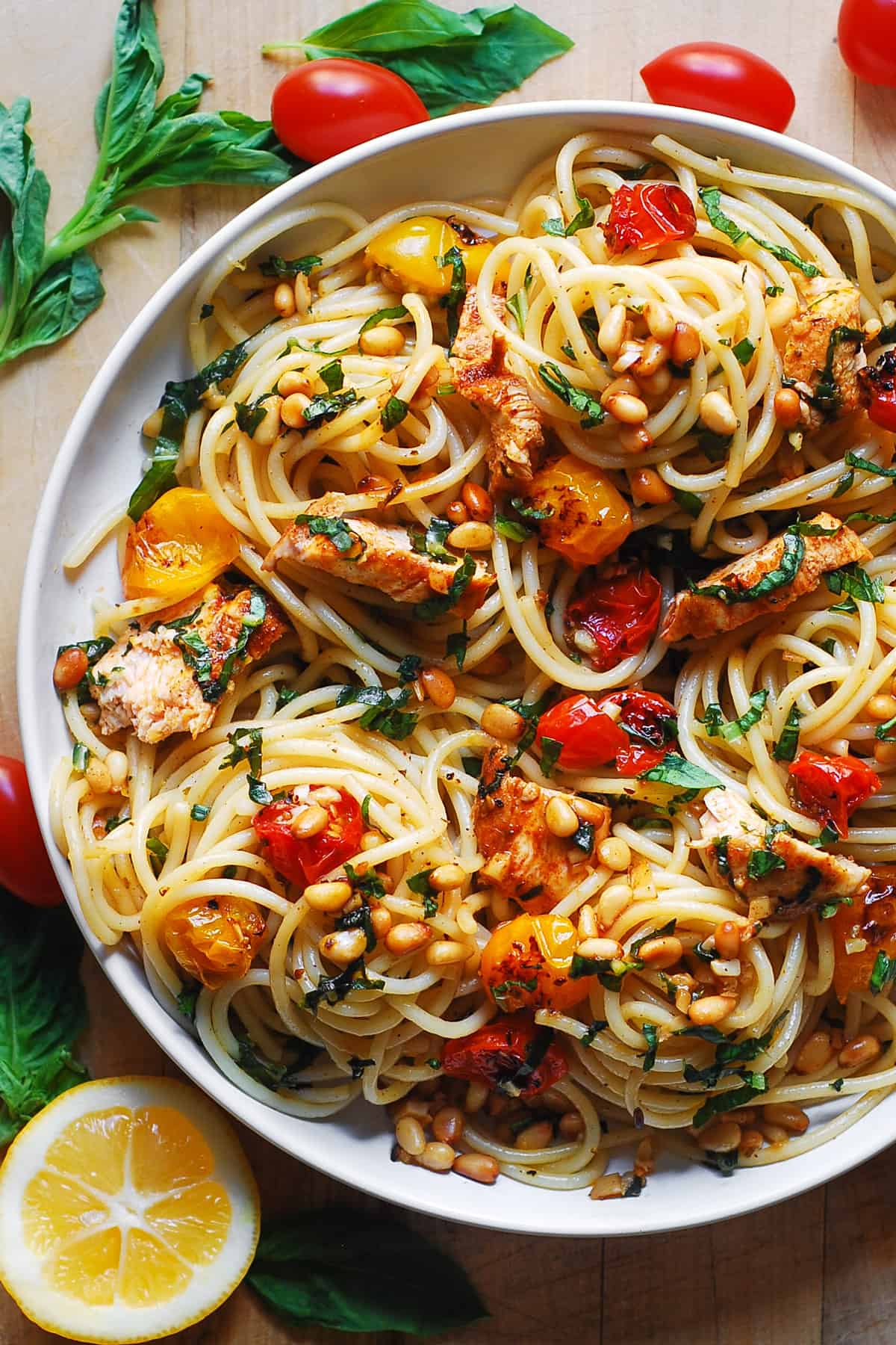 pasta with roasted cherry tomatoes, chicken, pine nuts, and lemon garlic butter sauce on a plate
