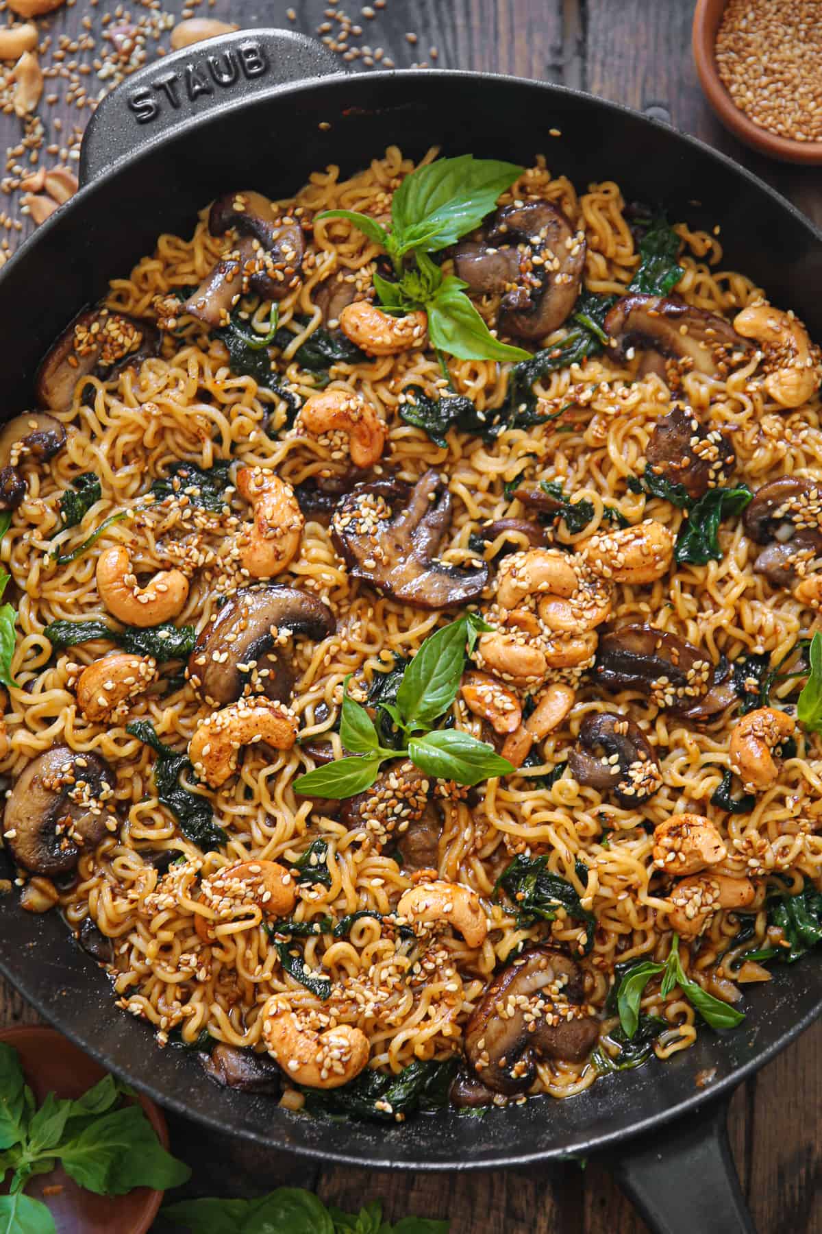 vegetarian ramen noodles with mushrooms, spinach, and cashews in a cast iron skillet