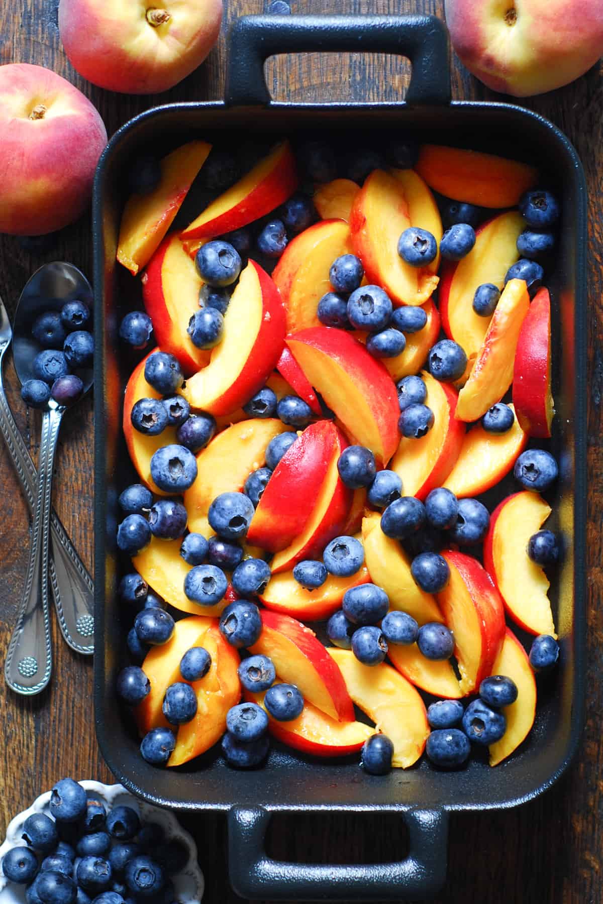 blueberries and sliced peaches in a baking dish