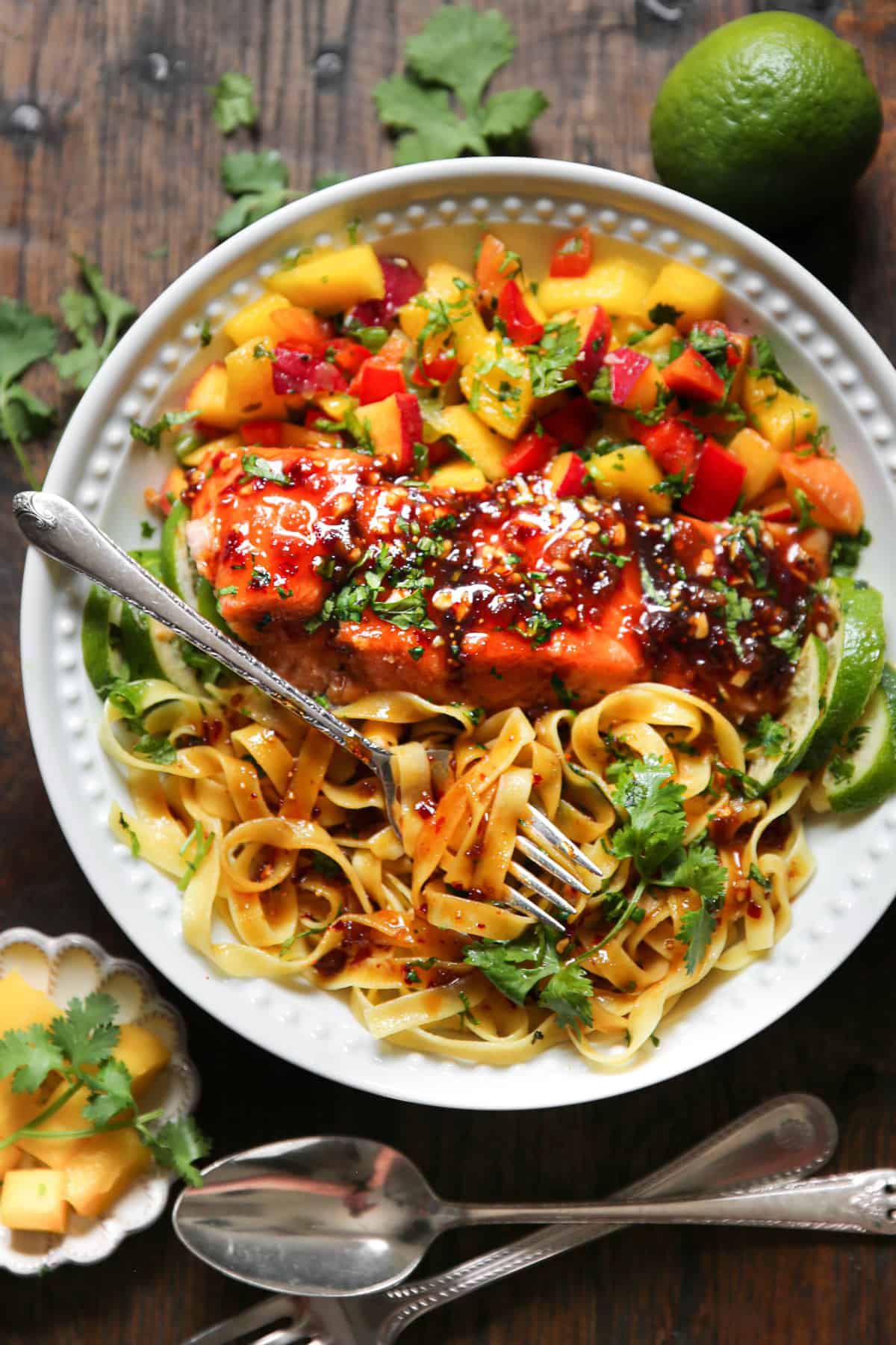 Asian Glazed Salmon with Mango Peach Salsa and Pasta in a white bowl