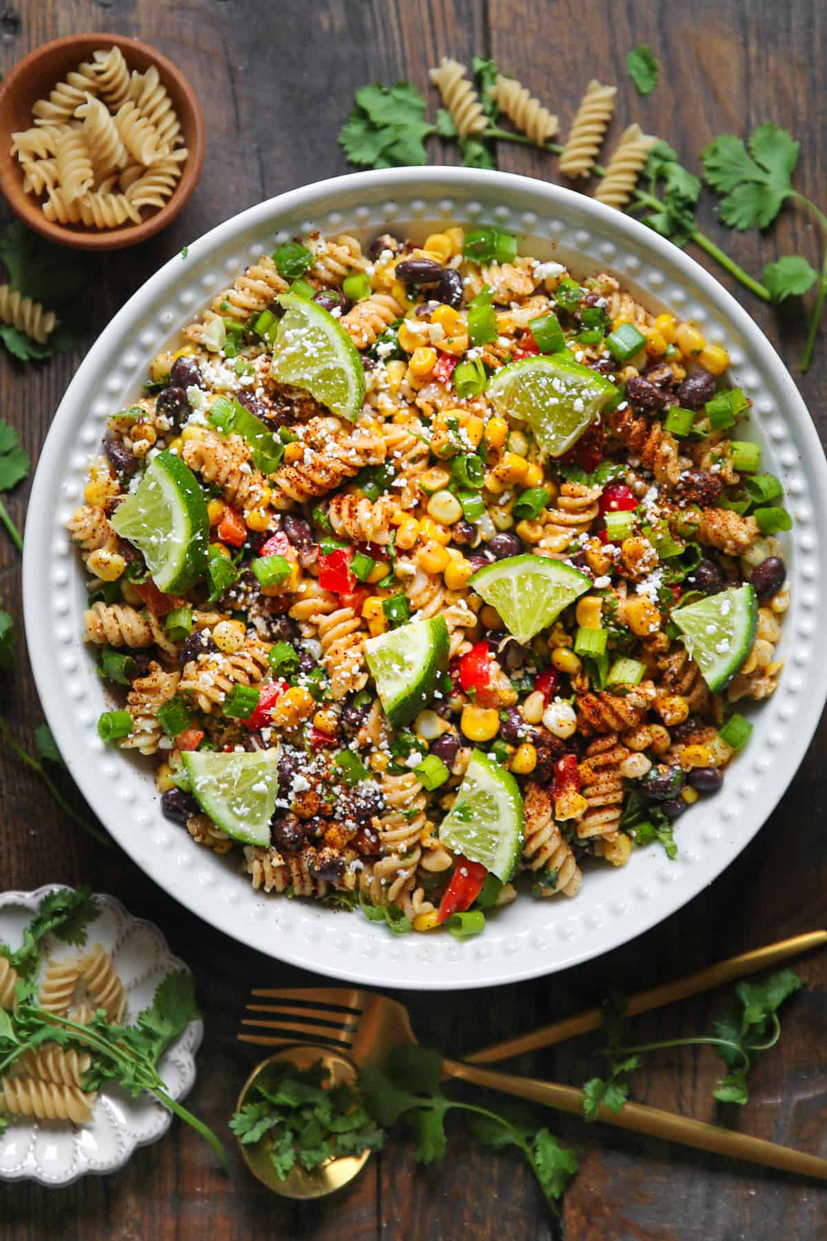 Mexican Street Corn Pasta Salad with slices of lime in a white bowl