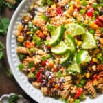 Mexican Street Corn Pasta Salad with sliced limes in a bowl