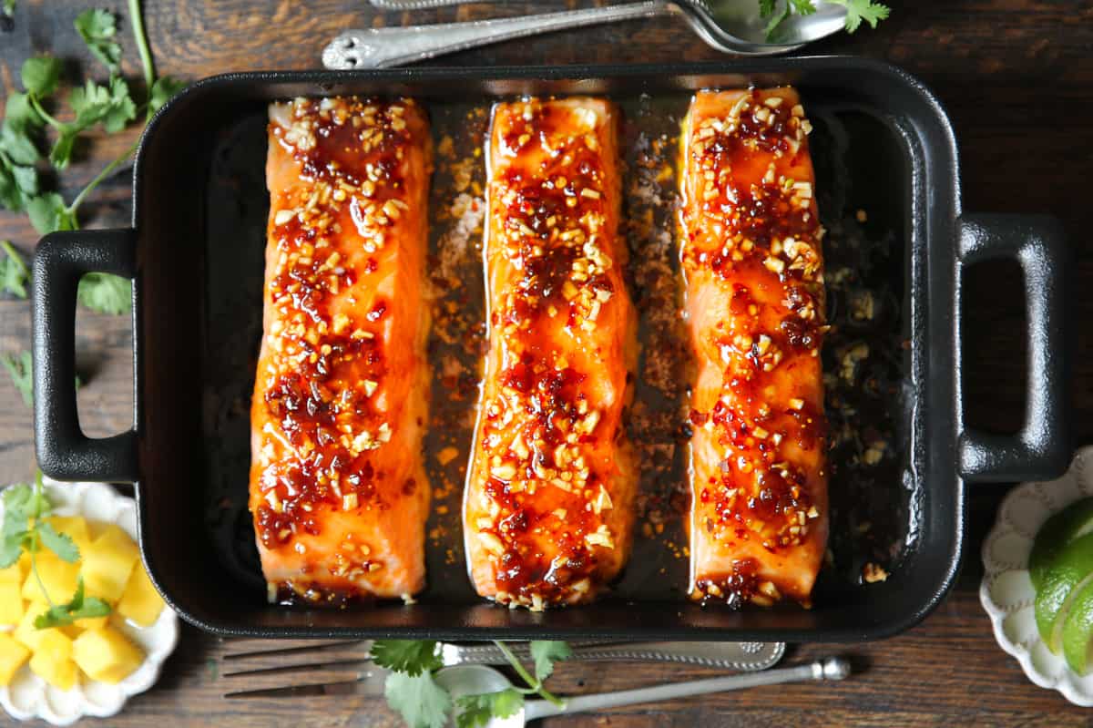 three baked salmon fillets with the honey garlic glaze in a baking dish