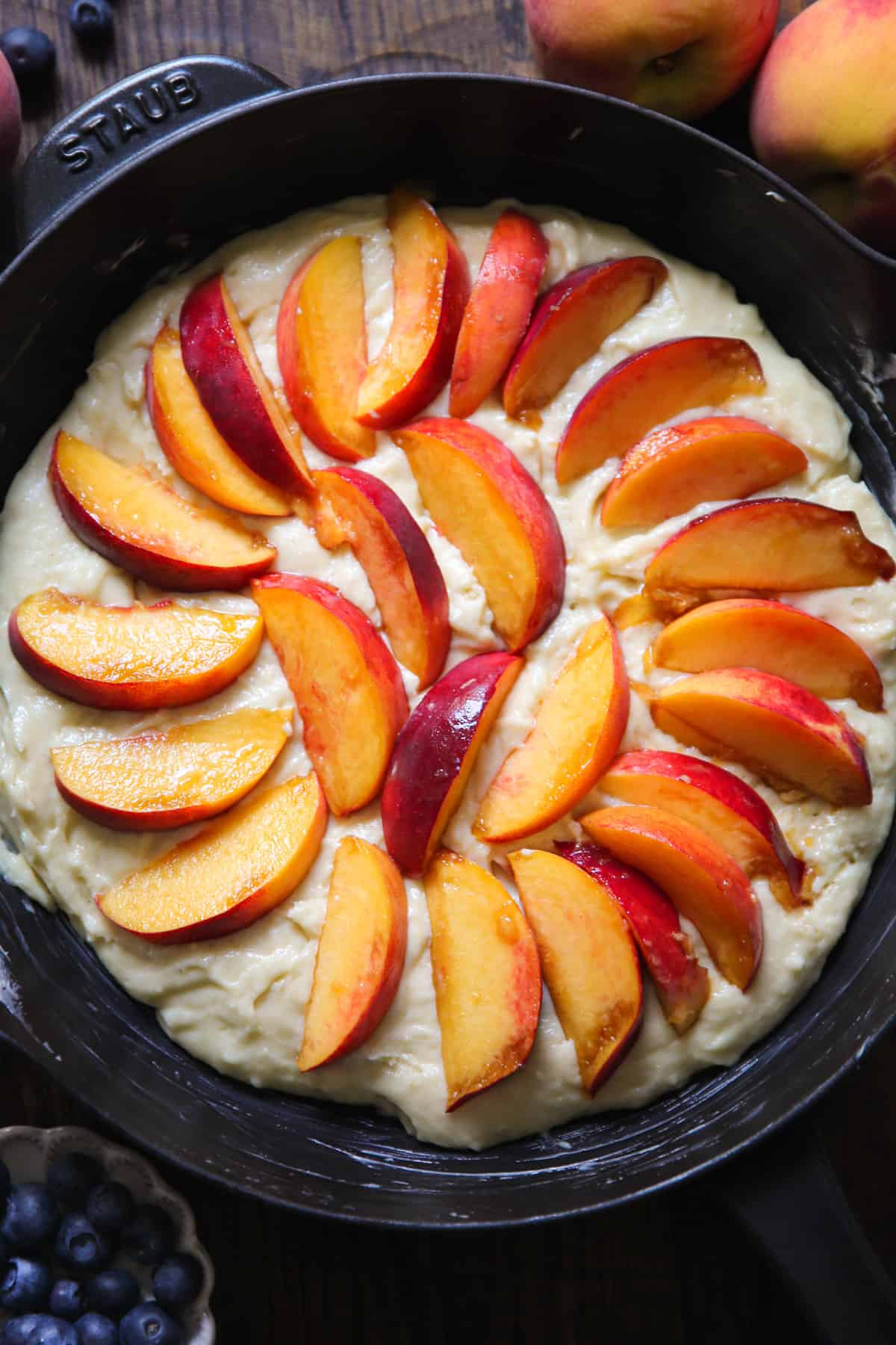cake batter with fresh Peaches in a cast iron skillet