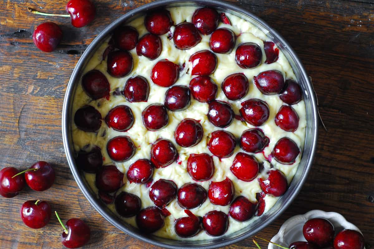 second (final) layer of cake batter topped with more fresh cherries in a springform pan