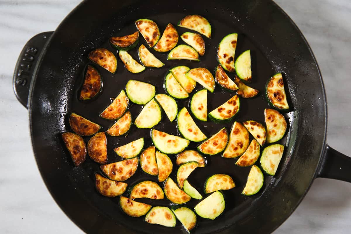 cooked sliced zucchini in a cast iron skillet