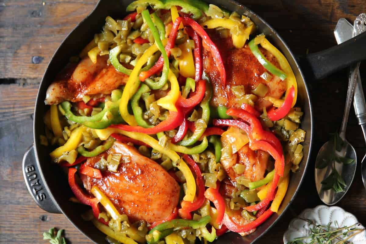 chicken, bell peppers, green chiles in a cast iron skillet