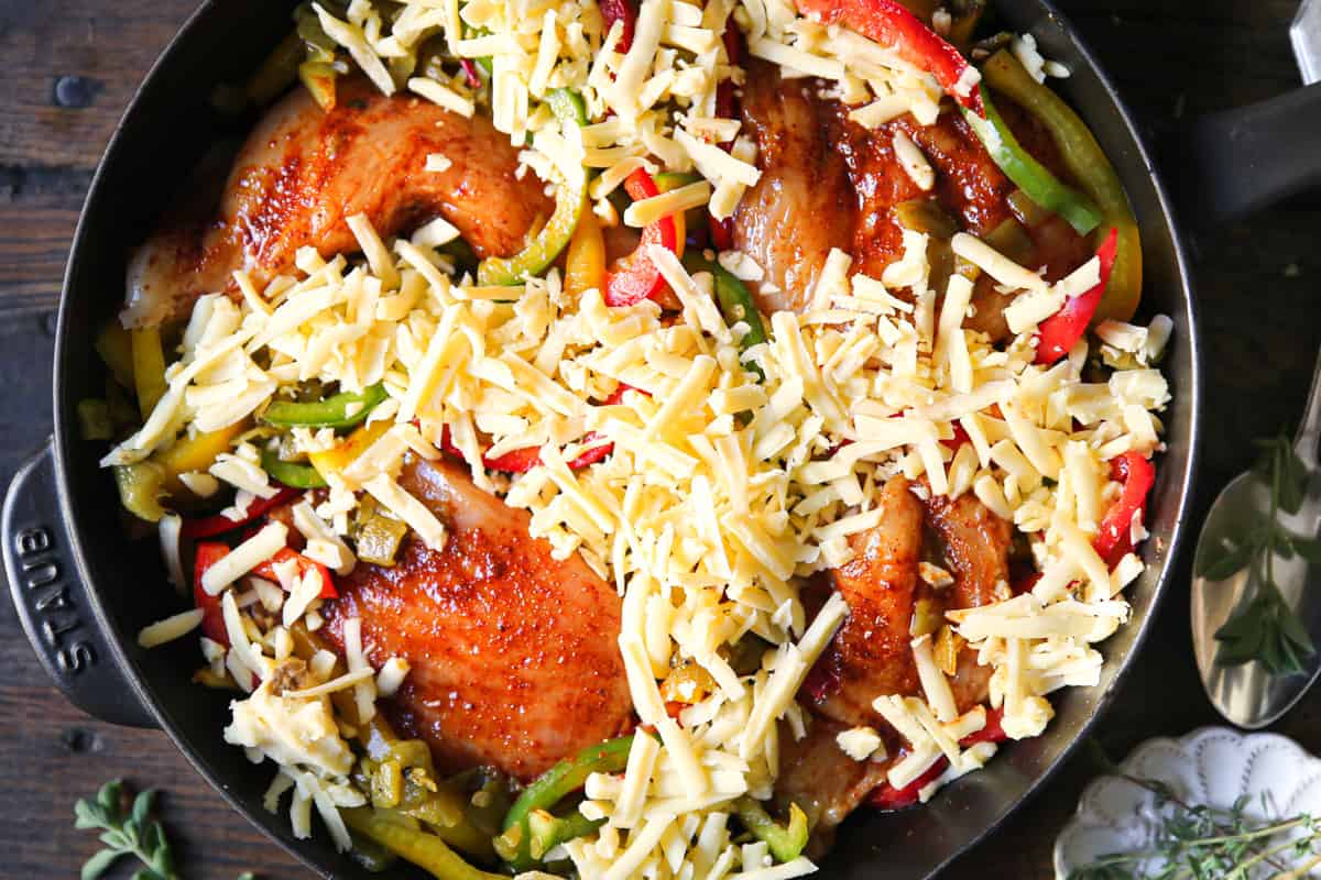 chicken, bell peppers, green chiles, shredded cheese in a cast iron skillet