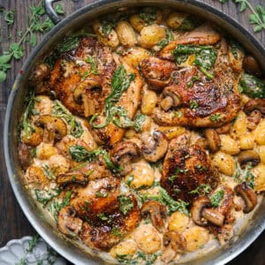 creamy chicken gnocchi with mushrooms and spinach - in a stainless steel pan.