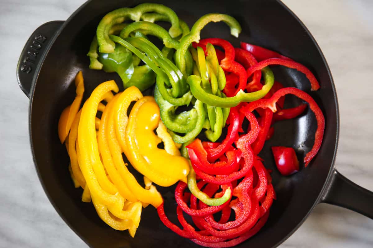 sliced bell peppers in a cast iron skillet