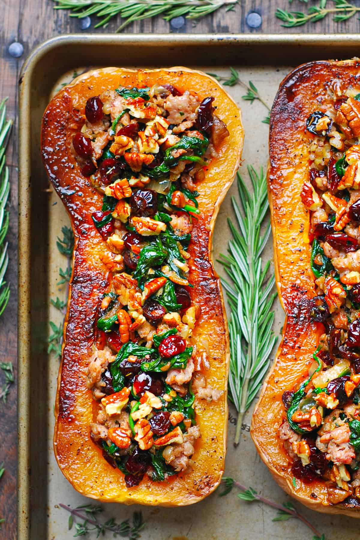 Sausage Stuffed Butternut Squash with Spinach, Pecans, and Cranberries - on a baking sheet.