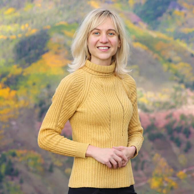 photo of the content-creator Julia from JuliasAlbum.com site - she is wearing a yellow sweater against the Autumn background.